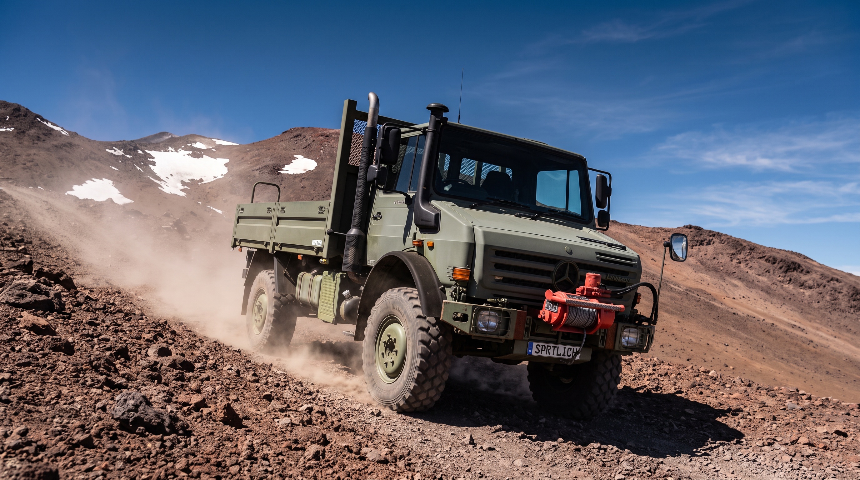 A modern heavy off-road Unimog climbing a high-altitude volcanic slope