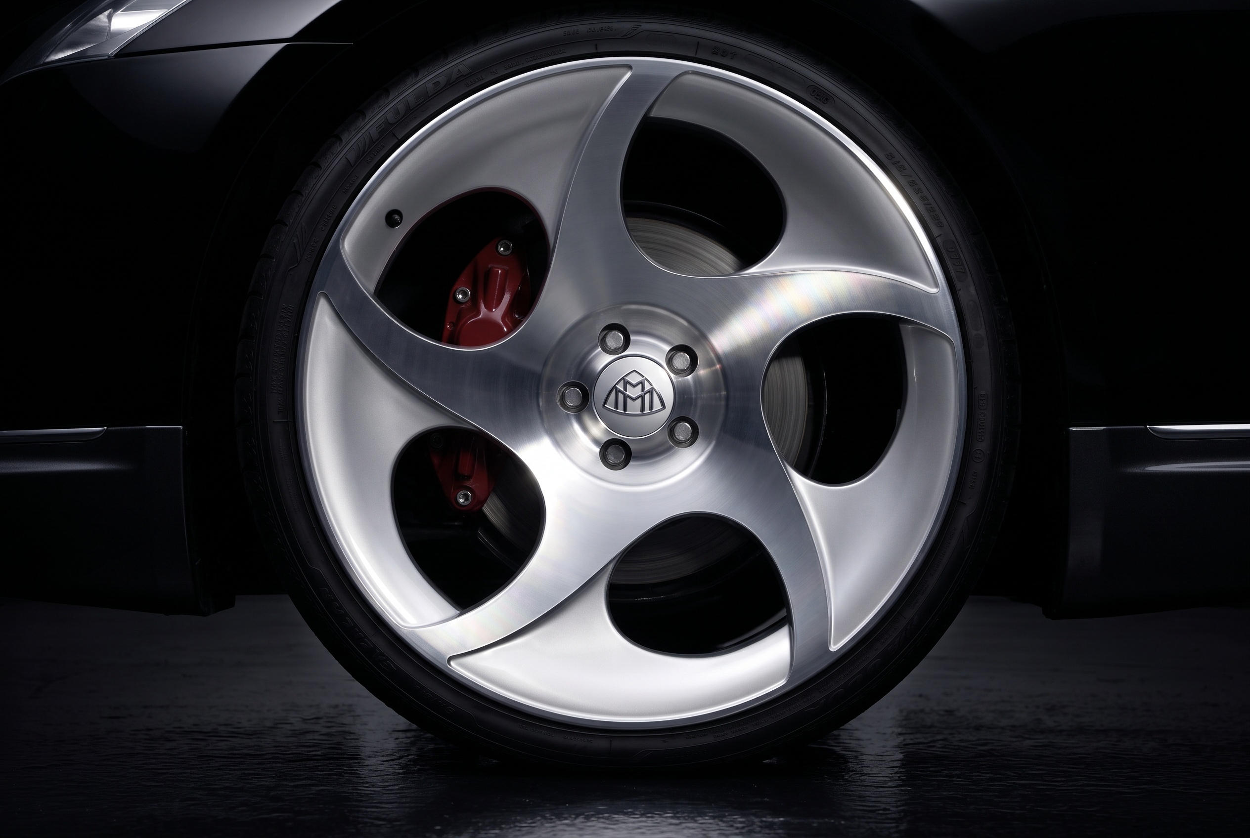 A 23-inch polished five-spoke Exelero wheel with red brake caliper